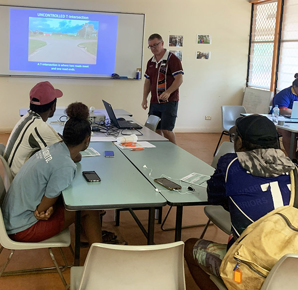 Learner drivers in class watching teacher and presentation