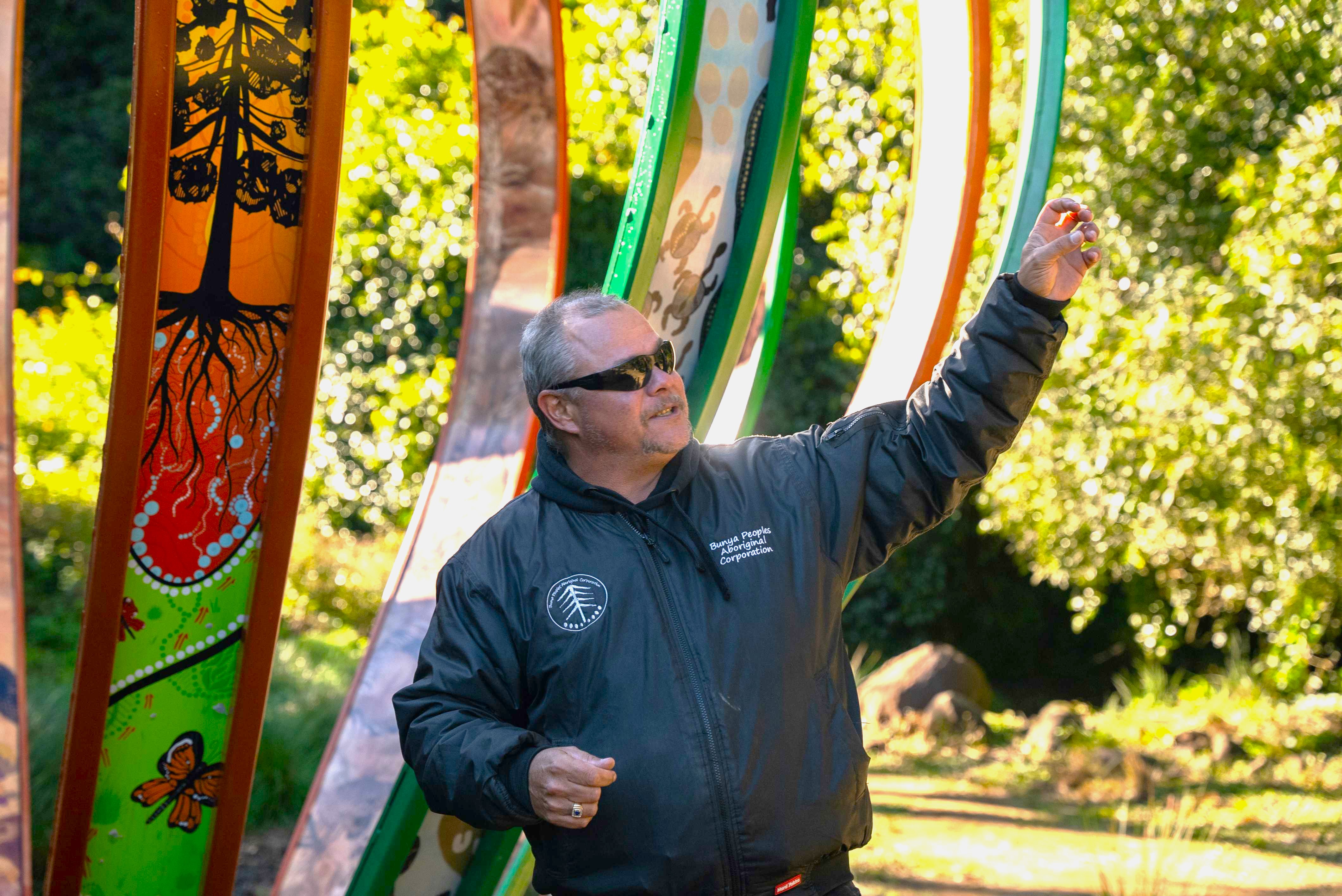 Indigenous ranger presents a talk in front of Indigenous artwork