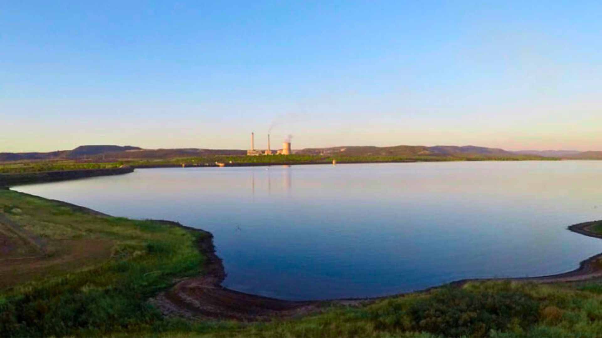 Reservoir with flat water and a power station visible in the distance.