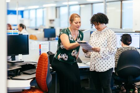 Two women in an office discussing a document