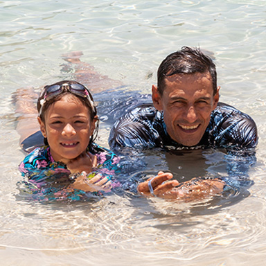 Father and daughter resting in a pool
