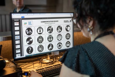 A person looking at a computer screen with disability icons on it