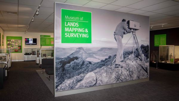 Entrance of museum showing large image of man looking into an old camera on top of a mountain