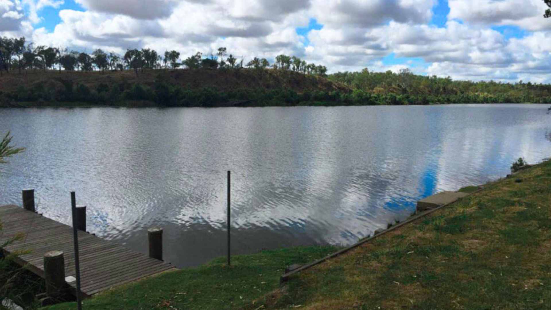 Wide river impoundment with jetty in the foreground and calm water.