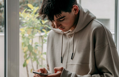 young male intensely looking at his phone