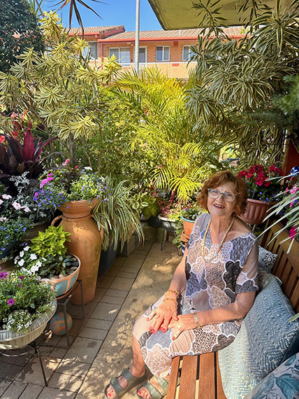 old woman sitting on a chair in her garden