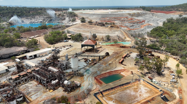 Remnant plant and equipment on site at Mount Garnet, with the open cut pit, evaporators, and the tailings storage facility in the background.