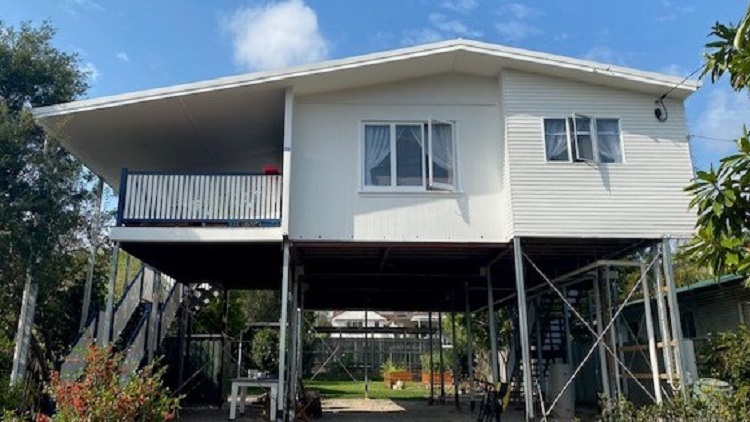 photo of a yellow house being raised and constructed